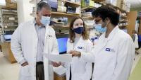 Three researchers from the CCTI review a page of information in a research lab